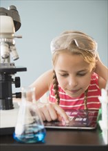 Caucasian girl using digital tablet in science lab