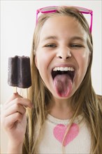 Caucasian girl with stained tongue from grape popsicle