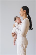Profile of Asian mother holding baby