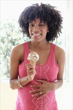 Pregnant African American mother eating ice cream cone