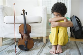 Angry mixed race boy refusing to practice violin