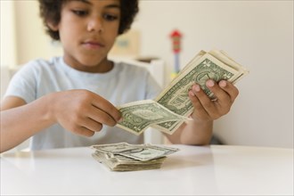 Mixed race boy counting money