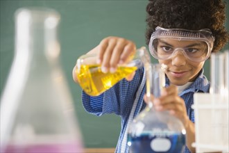 Mixed race boy experimenting in classroom science lab