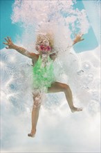Caucasian girl swimming underwater in pool