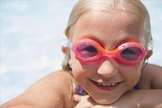 Caucasian girl wearing goggles in swimming pool