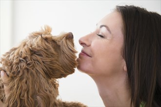 Caucasian woman kissing pet dog