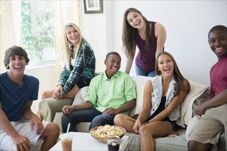Teenagers smiling on sofa at party