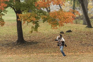 Man carrying girlfriend piggyback in park