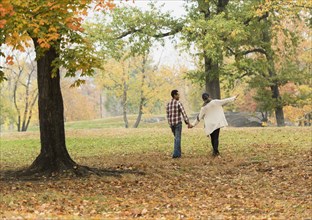 Couple holding hands and walking in park