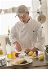 Korean chef slicing food in kitchen