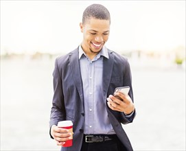 Black businessman using cell phone outdoors