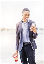 Black businessman using cell phone outdoors