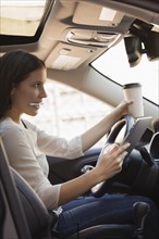 Caucasian woman multi-tasking while driving car