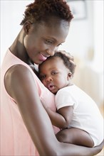 Black mother holding sleepy son