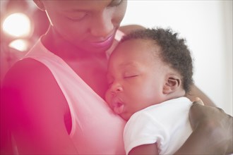 Black mother holding sleeping son