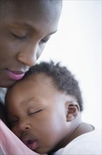 Close up of Black mother holding sleeping son