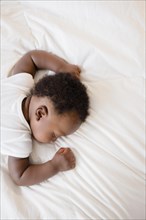 Overhead view of Black baby boy sleeping on bed