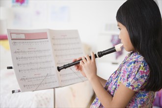 Vietnamese girl playing recorder from sheet music