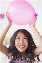 Vietnamese girl holding pink balloon
