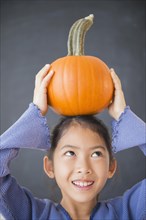 Vietnamese girl balancing pumpkin on head