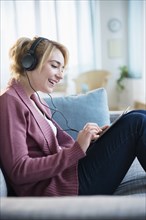 Caucasian woman listening to headphones and digital tablet