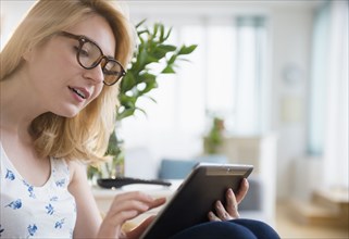 Caucasian woman in eyeglasses using digital tablet