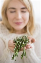 Caucasian woman smelling fresh herbs