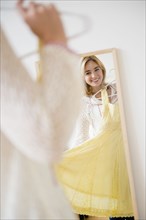 Caucasian woman admiring dress in mirror