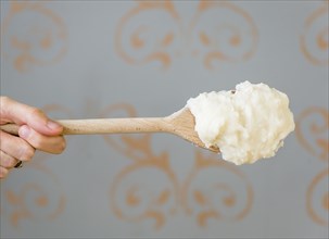 Close up of mashed potatoes on wooden spoon