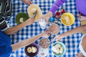 High angle view of children making ice cream sundaes