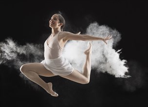 Hispanic dancer leaping in cloud