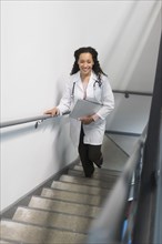 High angle view of mixed race doctor climbing staircase
