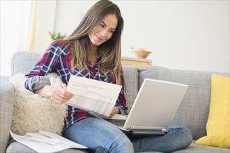 Caucasian woman paying bills on laptop