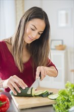 Caucasian woman slicing vegetables for salad