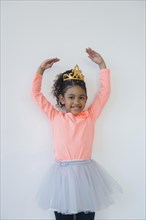 Smiling mixed race ballerina posing in tiara