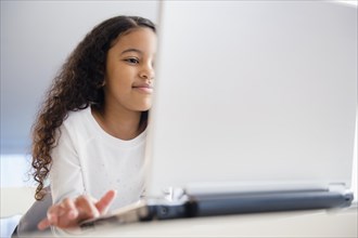 Close up of mixed race girl using laptop