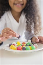 Close up of mixed race girl eating gumdrops