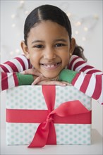 Mixed race girl smiling with wrapped gift