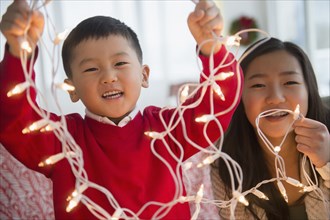Asian children playing with Christmas string lights