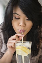 Pacific Islander woman drinking lemon water