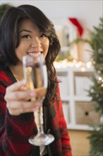 Pacific Islander woman toasting Christmas with champagne