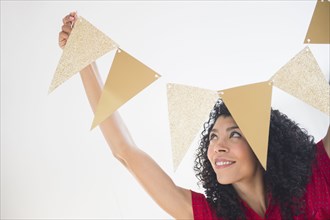 Mixed race woman hanging celebration banner