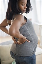 Black pregnant woman stretching her back
