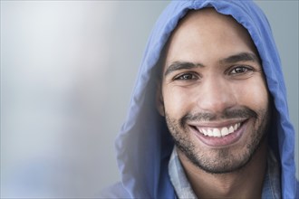 Smiling Hispanic man wearing hoodie
