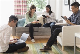 Friends using technology in living room