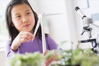Chinese student examining model wind turbine in science lab