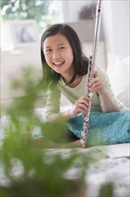 Chinese girl holding flute on bed
