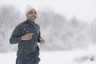 Black runner jogging in snow