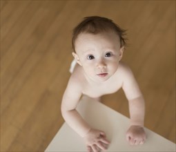 Caucasian baby looking up at table