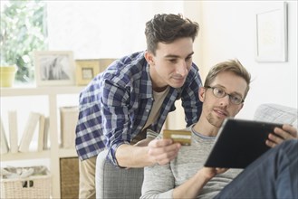 Caucasian gay couple shopping online on digital tablet